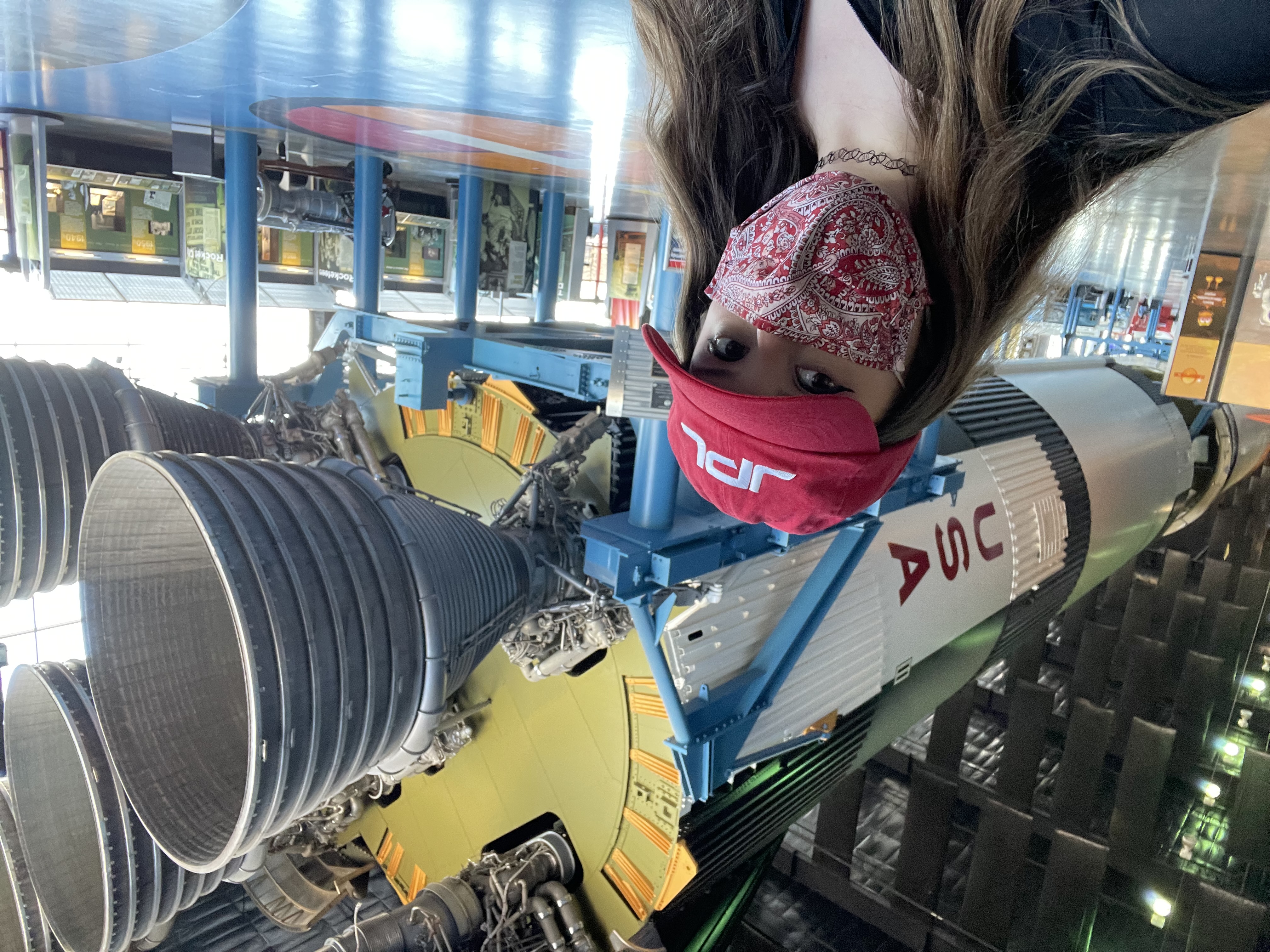 Alyssa Mills stands in front of a NASA rocket